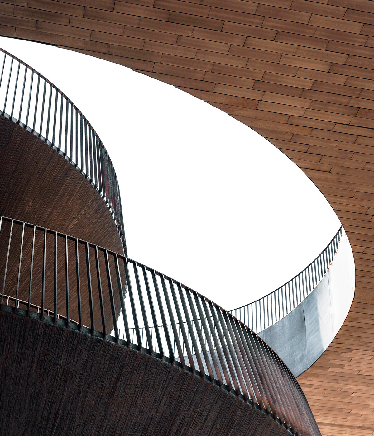 Curved metal stairs around shiplap wood walls