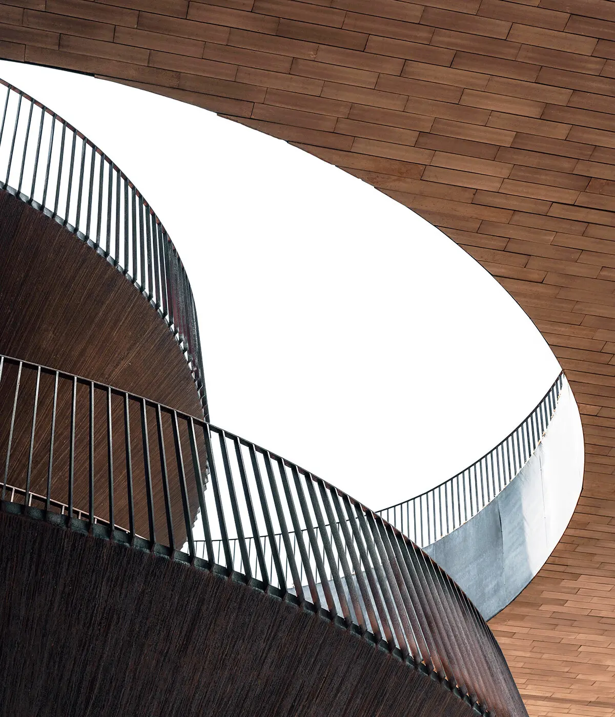 Curved metal stairs around shiplap wood walls